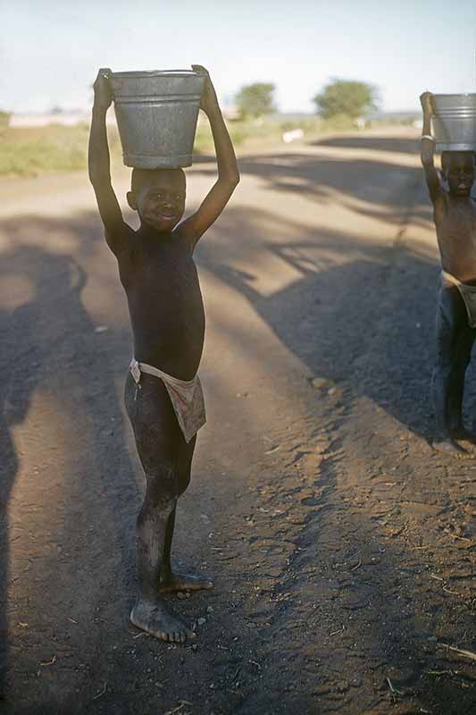 Boys carrying buckets, Molepolole