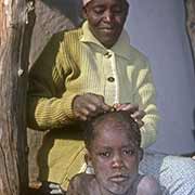 Shaving the head of her son, Serowe