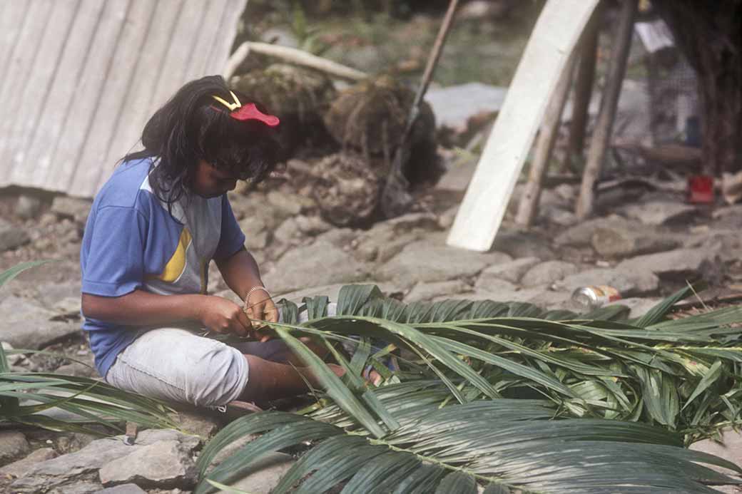 Girl weaving palm leaves
