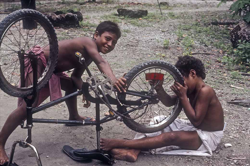 Boys fixing bicycle, Woleai
