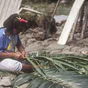 Girl weaving palm leaves
