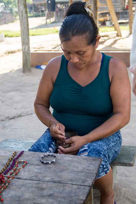 Tiriyó woman making necklace